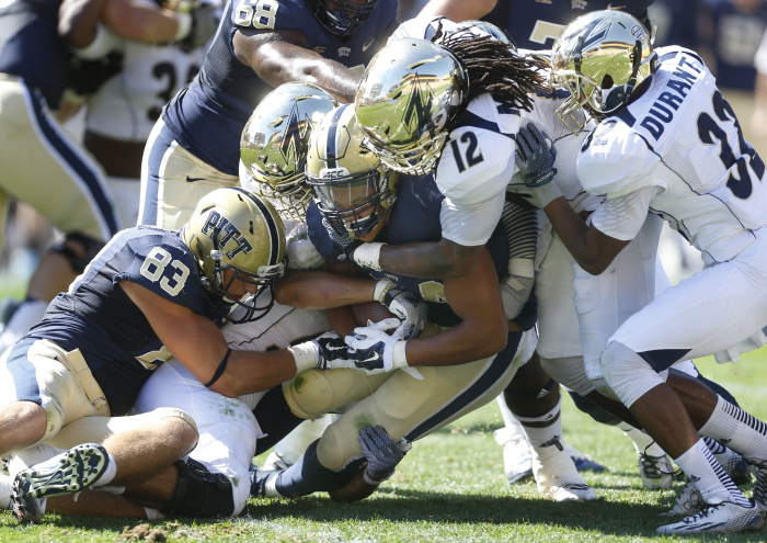 The Akron defense led by linebacker C.J. Mizell (12) and cornerback Martel Durant (32) stop Pittsburgh running back James Conner (24) on a run in the second quarter of the NCAA college football game on Saturday, Sept. 27, 2014 in Pittsburgh. Akron won 21-10. (AP Photo/Keith Srakocic)