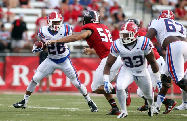 Sep 6, 2014; Lafayette, LA, USA; Louisiana Tech Bulldogs running back Kenneth Dixon (28) carries the ball beside Louisiana-Lafayette Ragin Cajuns defensive end Dominique Tovell (52) in the first half at Cajun Field. Louisiana Tech defeated Louisiana-Lafayette Ragin Cajuns 48-20. Mandatory Credit: Crystal LoGiudice-USA TODAY Sports