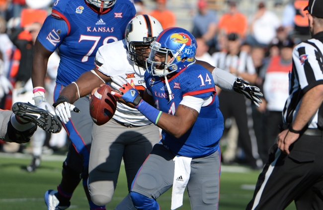 Oct 11, 2014; Lawrence, KS, USA; Kansas Jayhawks quarterback Michael Cummings (14) is sacked by Oklahoma State Cowboys defensive end Emmanuel Ogbah (38) in the first half at Memorial Stadium. Mandatory Credit: John Rieger-USA TODAY Sports