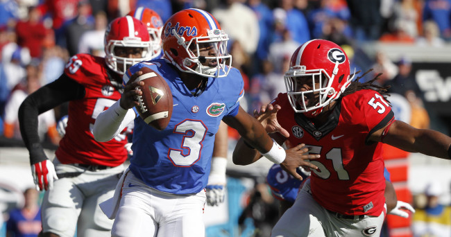 Nov 1, 2014; Jacksonville, FL, USA; Florida Gators quarterback Treon Harris (3) stiff arms as Georgia Bulldogs linebacker Ramik Wilson (51) rushes during the first quarter at EverBank Field. Mandatory Credit: Kim Klement-USA TODAY Sports