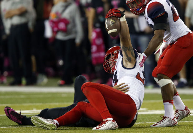 Scooby Wright holds up ball after stripping Marcus Mariota (Photo Courtesy of Kelly Pressnell/Arizona Daily Star)